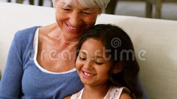 祖母和孙女在客厅看相册时互动视频的预览图