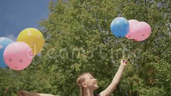 年轻女孩带着鲜艳的彩色球微笑着在相机上摆姿势情绪良好积极向上视频的预览图