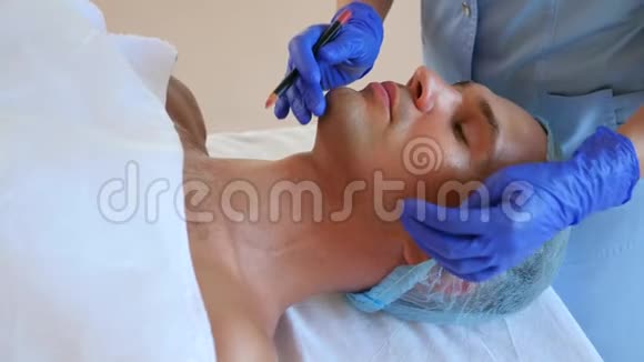 美容师用铅笔在一个人的脸上做标记整形手术轮廓面塑料为男性4k视频的预览图