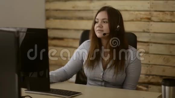 女孩成功地在呼叫中心工作与她的客户交谈坐着说话微笑视频的预览图