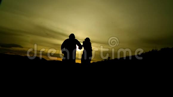 浪漫的情侣在山顶奔跑背景是美丽的日落视频的预览图