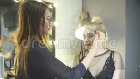 年轻的女化妆师在美容院化妆金发视频的预览图