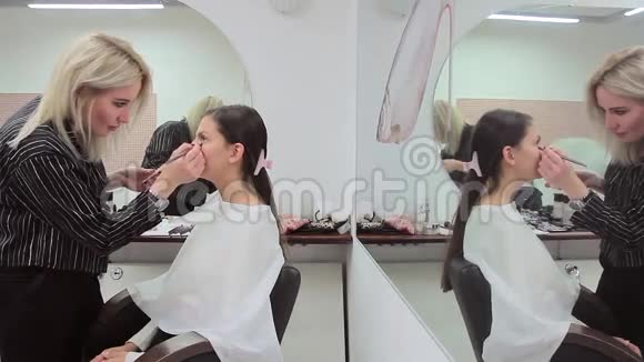 化妆师和模特在镜子前工作视频的预览图