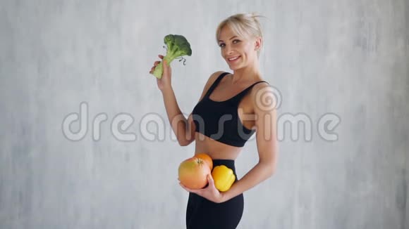 运动女性手里拿着新鲜水果和蔬菜健康的饮食观念视频的预览图