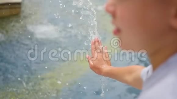 一个孩子在喷泉里玩喷水夏日阳光明媚户外娱乐和游戏视频的预览图