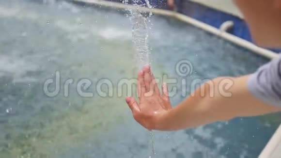 一个孩子在喷泉里玩喷水夏日阳光明媚户外娱乐和游戏视频的预览图