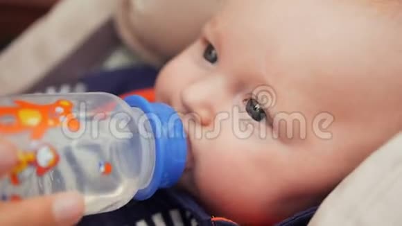 漂亮的婴儿从瓶子里喝水视频的预览图