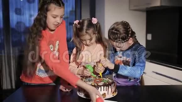 三个有趣的小女孩在蛋糕上画了一棵圣诞树和圣诞老人为父母提供蛋糕惊喜视频的预览图