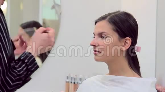 化妆师在化妆模型中使用遮瑕膏视频的预览图