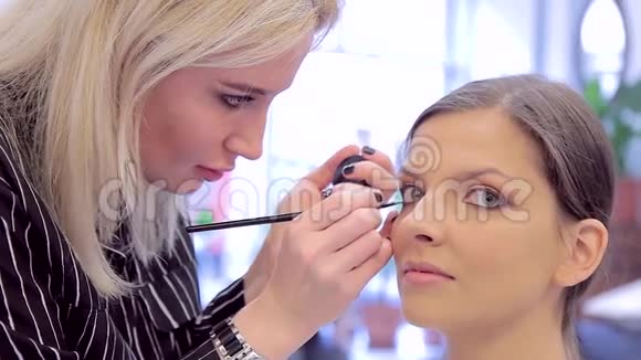 美丽的少女和化妆师与眼线视频的预览图