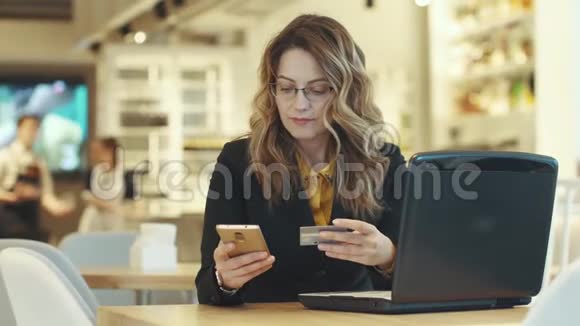 一个女商人在网上购买并输入信用卡号码视频的预览图