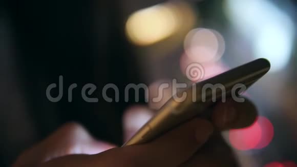 年轻女子双手使用智能手机与模糊的博克街城市夜光背景4K泰国曼谷视频的预览图