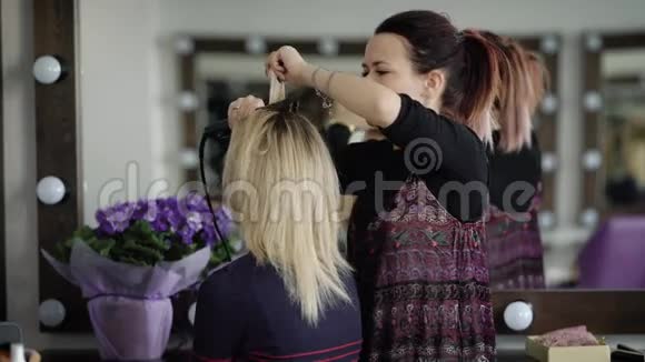 豪华美容院的女理发师正在与年轻模特合作师傅和专业人士一起理发视频的预览图