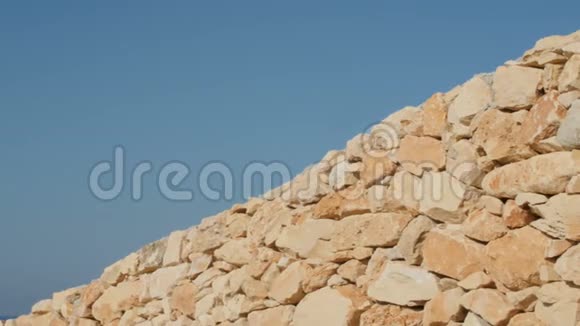 蓝天背景上的石墙的碎片视频的预览图