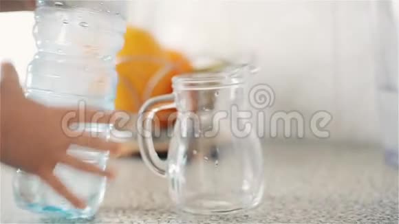 一个小孩从塑料瓶里倒进一壶干净的饮用水里视频的预览图