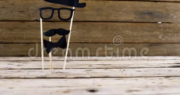 木制木板上的蝴蝶结眼镜和假胡子视频的预览图