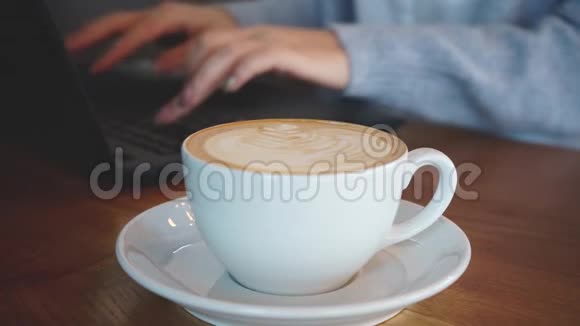 女人在手提电脑和喝咖啡视频的预览图