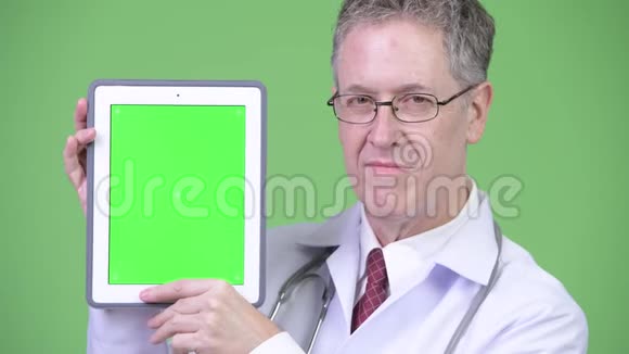 快乐成熟男医生的画像显示数字平板电脑视频的预览图