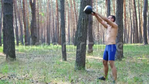 年轻的运动员赤裸的躯干进行力量锻炼与重量一个交叉配合的元素慢慢视频的预览图