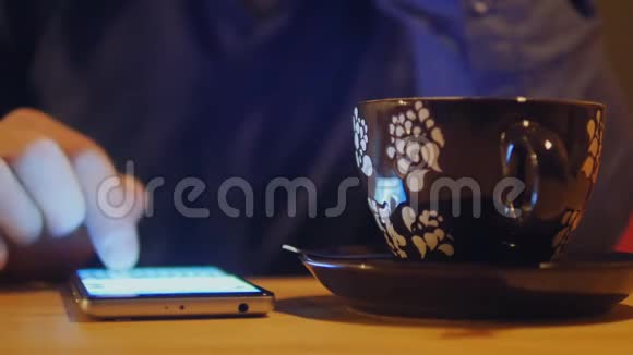 关闭人手使用智能手机短信电话放在桌子上旁边是一杯咖啡视频的预览图