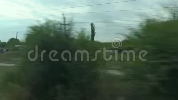 从移动列车的窗口拍摄俄罗斯秋季景观村庄田野森林种植天空视频的预览图