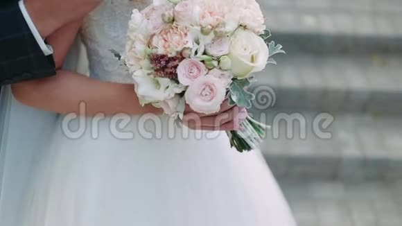 快乐的新娘和新郎你的手新郎用花束拥抱新娘幸福的眼泪特写视频的预览图