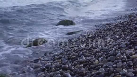 海上冲浪波浪在海岸卵石上流动视频的预览图