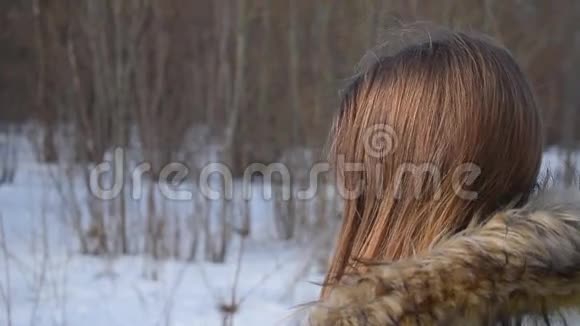 冬季公园里的女孩穿暖和帽子高清视频后景视频的预览图