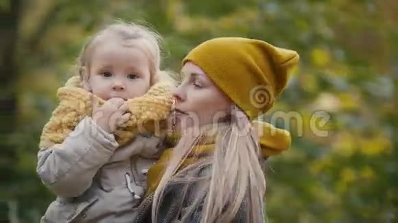 妈妈和女儿小女孩在一个秋天的公园里玩妈妈和孩子玩得很开心旋转着闭上眼睛视频的预览图