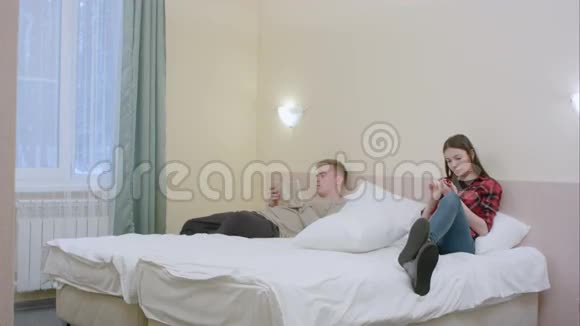 漂亮的女孩扰乱了她的男朋友而他正在读书这对夫妇开始用枕头打架视频的预览图