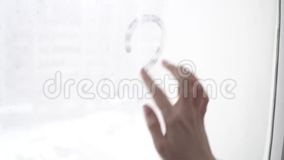 手在冷雾的窗户背景上画出爱的心特写图像视频的预览图