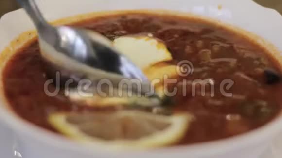 用勺子搅拌汤加柠檬和橄榄的汤视频的预览图