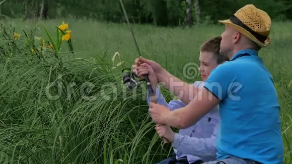 有魅力的人教他的儿子用鱼竿钓鱼视频的预览图