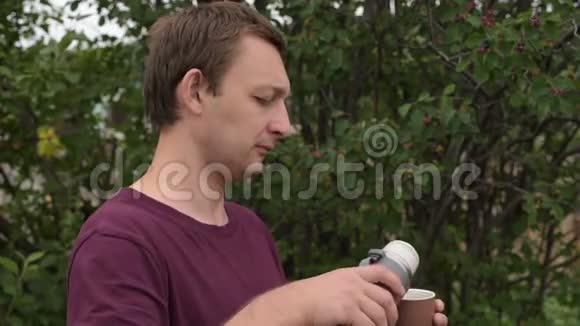 带热水瓶的人在户外喝茶视频的预览图
