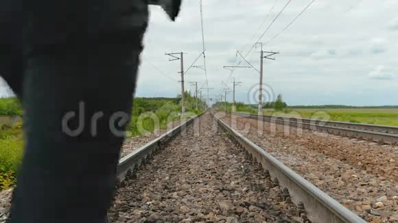 一个穿着商务服的人在铁轨上奔跑手里拿着一台笔记本电脑视频的预览图