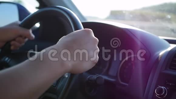 那家伙在晴天开车日落的时候手和方向盘特写视频的预览图