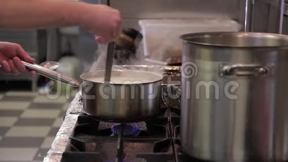 厨师在餐馆的厨房里用炖锅煮白米饭视频的预览图