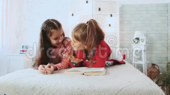 两个小朋友穿着睡衣他们在看书他们谈论和讨论这本书视频的预览图
