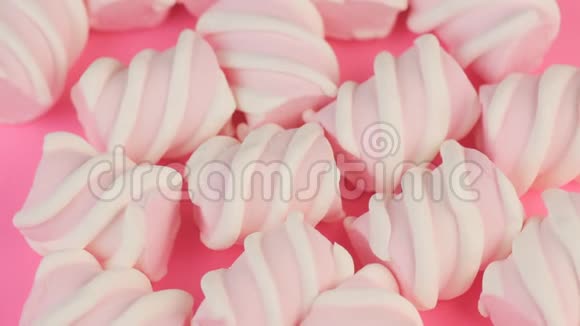 粉红背景下许多不同扭曲的棉花糖的顶部视图冬季食物概念视频的预览图