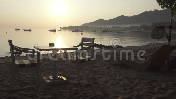 海滩上的餐桌等待游客的早餐清晨的日出在热带的印尼巴厘岛海滩上视频的预览图