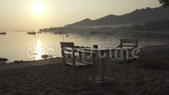 海滩上的餐桌等待游客的早餐清晨的日出在热带的印尼巴厘岛海滩上视频的预览图