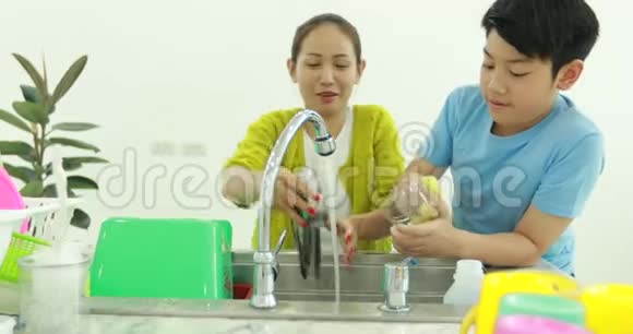幸福的亚洲家庭母子一起在家洗菜带着笑脸视频的预览图