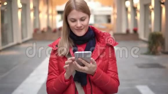 商场里有智能手机的漂亮女人浏览互联网和她的朋友交流视频的预览图
