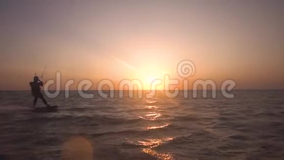 一个人在黎明时分在海上做风筝冲浪动作很慢视频的预览图