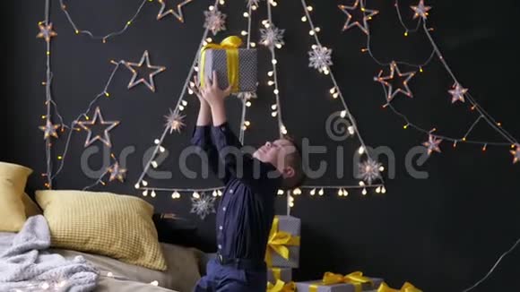 男孩把圣诞礼物放在圣诞景色的背景上视频的预览图