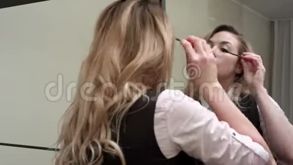 年轻漂亮的女人在镜子前化妆视频的预览图