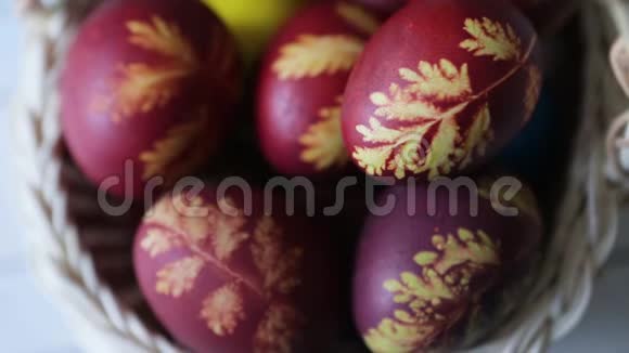 复活节彩蛋放在一个篮子里放在乡村木制的背景上白色背景上的多色复活节彩蛋快乐的复活节视频的预览图