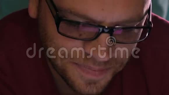 英俊的年轻人戴着黑色眼镜用他的平板电脑微笑着玻璃中反射的屏幕4K关闭视频的预览图