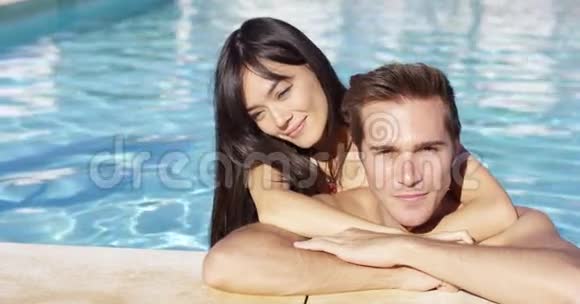 英俊的微笑情侣在游泳池拥抱视频的预览图