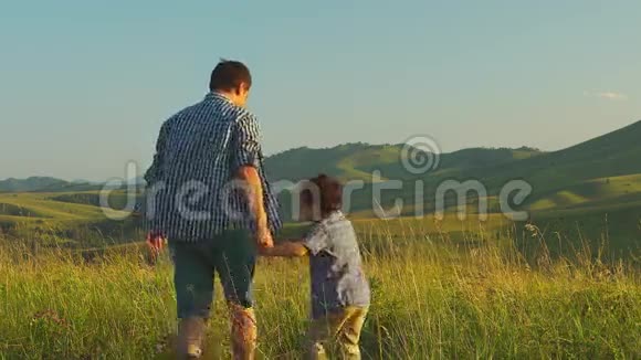 父亲带着儿子在风景优美的背景下走来走去视频的预览图